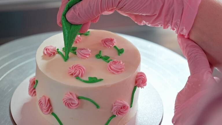 Eine Konditorin verziert eine Torte