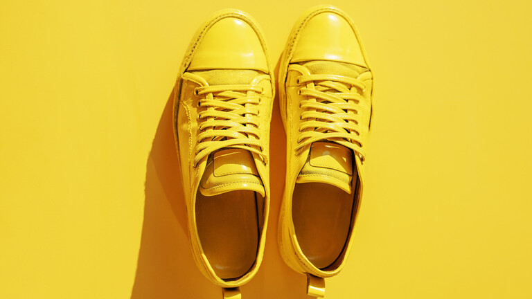 Blick auf gelbe Sneaker auf gelber Fläche