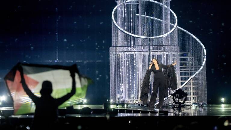 Ein Zuschauer hält eine palästinensische Flagge hoch, während Yuval Raphael bei der Generalprobe für das zweite Halbfinale des Eurovision Song Contests für Israel singt.