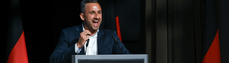 Ulrich Siegmund, Spitzenkandidat der AfD in Sachsen-Anhalt, umgeben von Deutschlandflaggen bei seiner Rede vor den Teilnehmern des Landesparteitages.