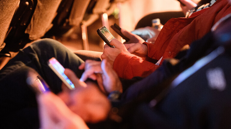 Smartphones in den Händen ihrer Besitzer