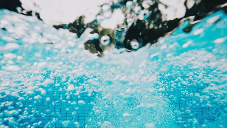 Wasserblässchen nach Sprung ins Freibad