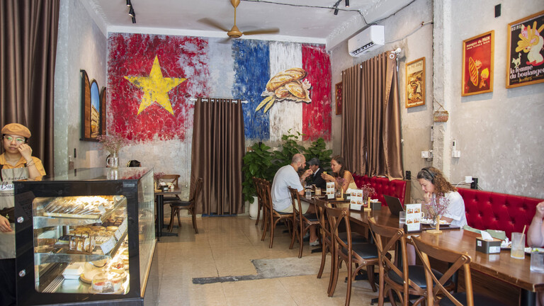 In einem vietnamesischen Café in Da Nang sitzen europäische aussehende Gäste an den Tischen und trinken Kaffee.