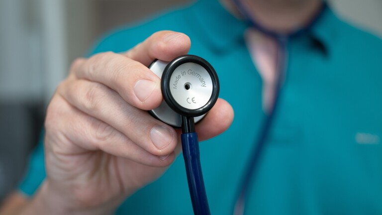 Person hält Stethoskop vor sich