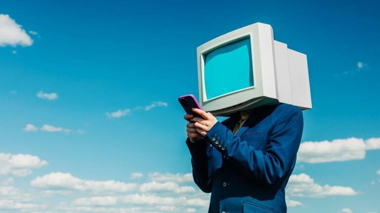 Person mit Retromonitor tippt auf Smartphone