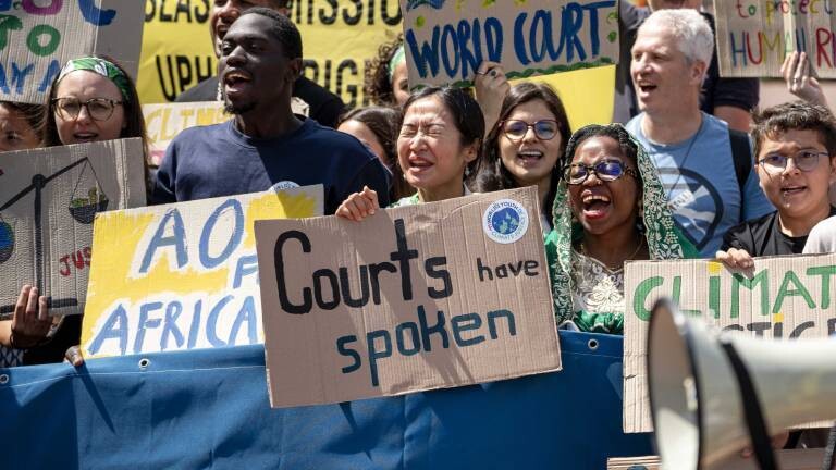 Demonstranten halten vor dem Internationalen Gerichtshof in Den Haag Schilder mit "Climate Justice" (dt. Klimagerechtigkeit) und "Court has spoken" (dt. Das Gericht hat gesprochen) (23.7.2025)