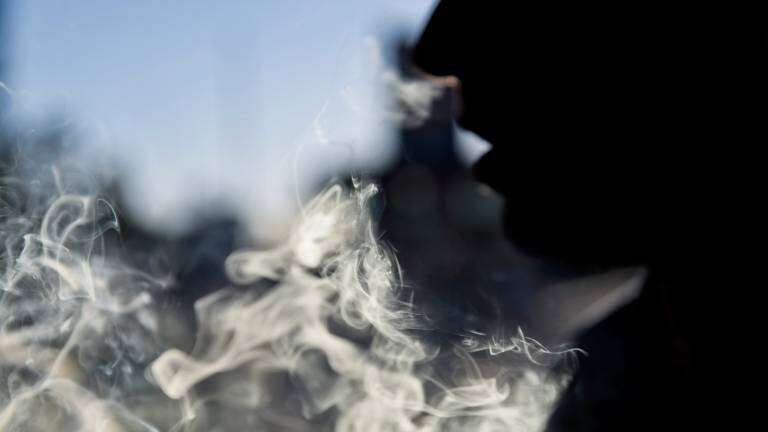 Person atmet Rauch aus