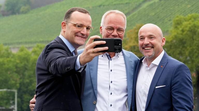 Jens Spahn (CDU) macht ein Selfie von sich, Alexander Hoffmann (CSU) und Matthias Miersch (SPD) auf der alten Mainbrücke in Würzburg (28.08.2025)