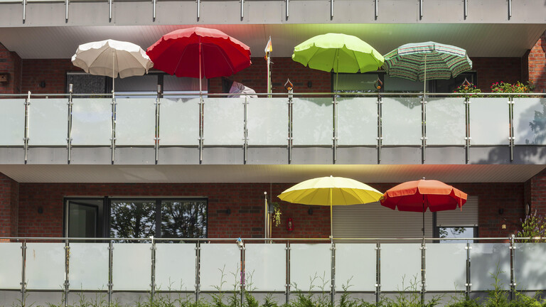 Balkone mit bunten Sonnenschirmen an einem modernen Wohngebäude, Bremerhaven, Bremen, Deutschland