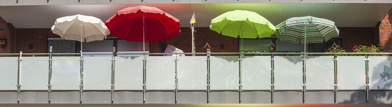Balkone mit bunten Sonnenschirmen an einem modernen Wohngebäude, Bremerhaven, Bremen, Deutschland