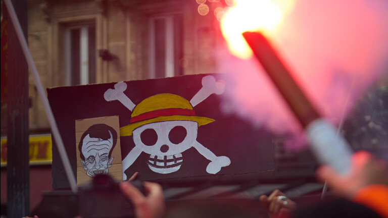Frankreich, Paris, 10. September 2025: Am Gare du Nord hält ein Demonstrant eine One-Piece-Flagge – Symbol der Bewegung. Foto: Valentin Faivre / Hans Lucas.
