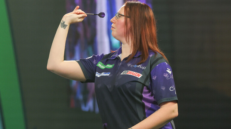 Dartspielerin Alexandra Palace trägt ein Vereinstrikot und zielt mit einem Dartpfeil bei der Darts WM in London.