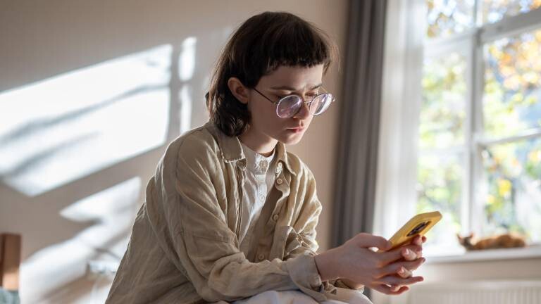 Eine Frau scrollt auf einem Handy