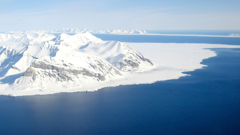 Verschneite und vereiste Berge der Arktis und Meer