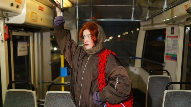 Eine Frau steht alleine in einer Bahn