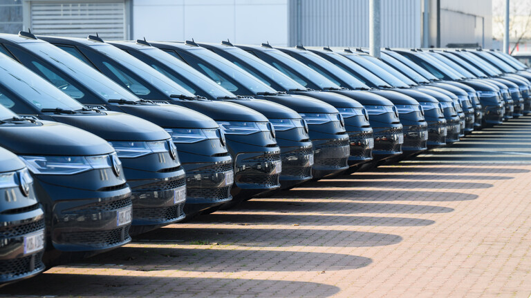 Viele schwarze Autos des gleichen VW-Modells stehen in einer Reihe