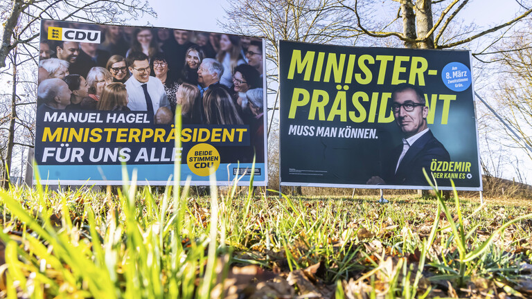 CDU- und Grünen-Wahlplakate auf einer Wiese