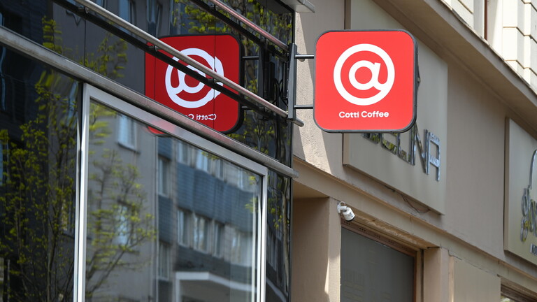 Schild der Kaffeekette Cotti Coffee an einer Hausfassade - ein weißes @-Zeichen auf rotem Grund