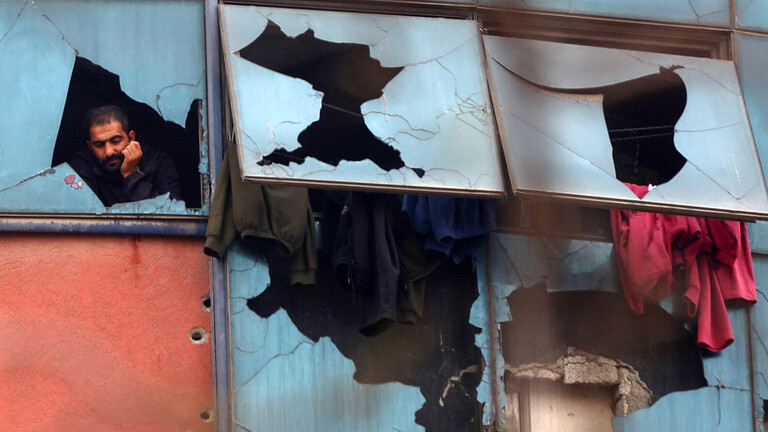 In Gaza-Stadt schaut ein Mann aus den zerstörten Fenstern eines Gebäudes nach draußen.
