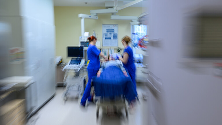 Medizinisches Personal behandelt eine liegende Person im Schockraum (Aufnahme mit Zoomeffekt)