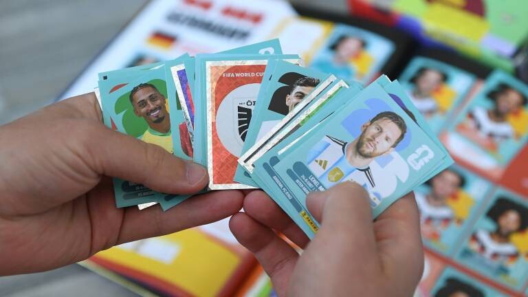 Eine Person hält Panini-Sticker in den Händen