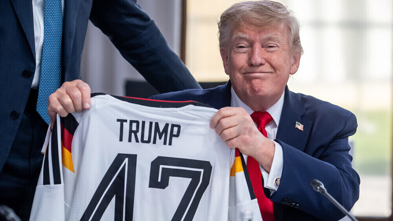 US-Präsident Donald Trump hält ein DFB-Fußball-Trikot mit dem Namen Trump und der Rückennummer 47, das er vom deutschen Kanzler Friedrich Merz bei einem Treffen der G7 bekommen hat (Evian, Frankreich, 16.06.2026)