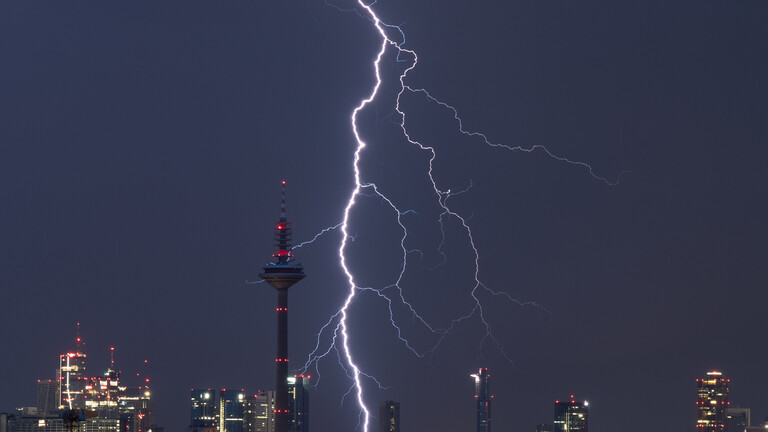 Am Nachthimmel über Frankfurt am Main ist ein Blitz sichtbar.