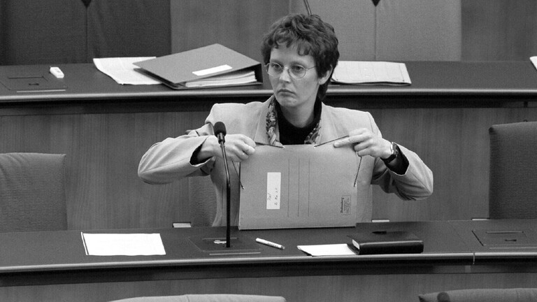 Frauenministerin Claudia Nolte sitzt 1997 alleine auf der Regierungsbank im Bonner Bundestag, in ihrer Hand Akten