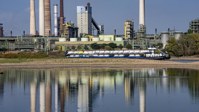 Extremes Niedrigwasser auf dem Rhein führt zur Bildung von Sandbänken. Der Frachter im kann nur mit reduzierter Ladung fahren. Im Hintergrund das Thyssenkrupp Steel Stahlwerk in Duisburg-Marxloh.