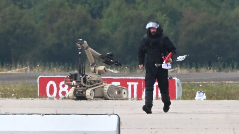 Ein Kriminaltechniker geht auf dem Flughafen Leipzig/Halle neben einem Sprengroboter, um die Drohne zu entschärfen.