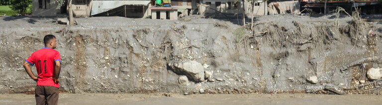 Mann steht am Ufer des Flusses Bhotekoshi und schaut auf die Schäden, die die Flut verursach hat (Nepal, 26.08.2026)
