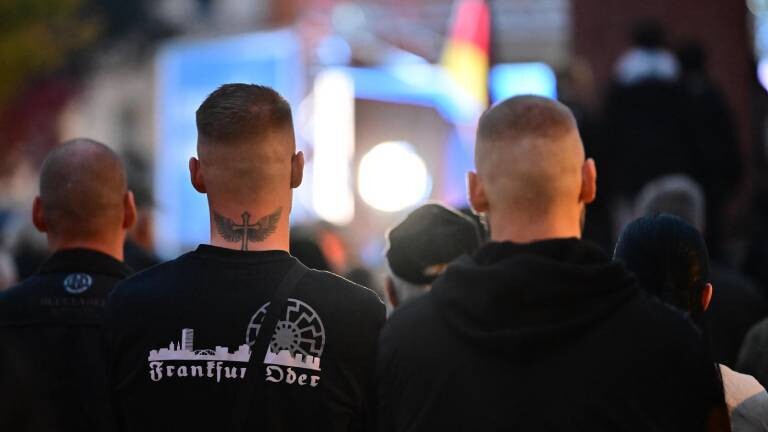 Ein Teilnehmer trägt während einer Kundgebung der AfD Brandenburg nach dem Übergriff auf einen 14-Jährigen vor einer Woche auf dem Leipziger Platz einen Pullover, auf dem „Frankfurt Oder“ steht und das rechtsextreme Symbol der Schwarzen Sonne gedruckt ist. Aufnahmedatum: 20.10.2026