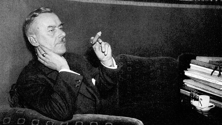 Die Abbildung zeigt den deutschen Schriftsteller Thomas Mann Zigarre rauchend.
