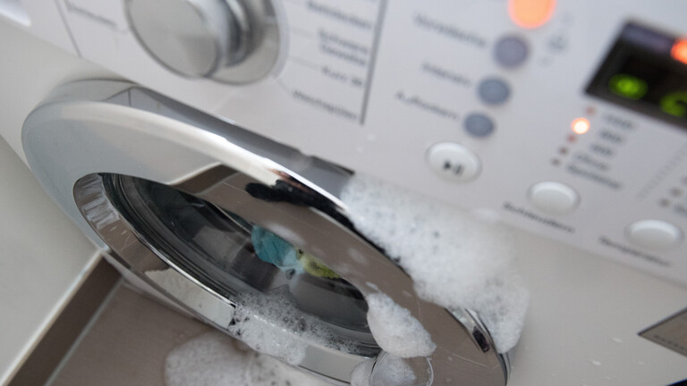 Schaum tritt aus einer geschlossenen Waschmaschine