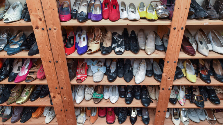Frauenschuhe stehen auf drei Holzregalen