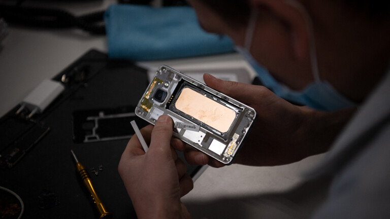 Ein Mitarbeiter überholt Smartphones, hauptsächlich iPhones