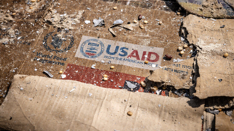 Auf einer Schachtel ist inmitten der verstreuten Überreste von Kisten und Materialien ein USAID-Logo zu sehen.