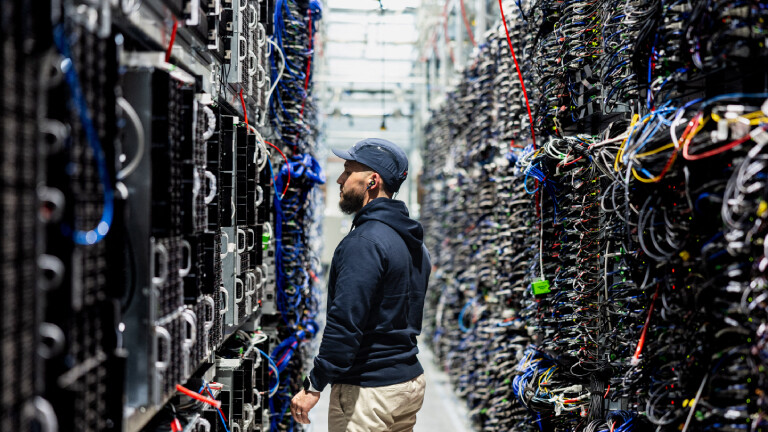 Ein Mitarbeiter der französischen Firma OVHcloud steht im April 2025 in Roubaix im Norden Frankreichs zwischen raumhohen mit Rechentechnik gefüllten Racks