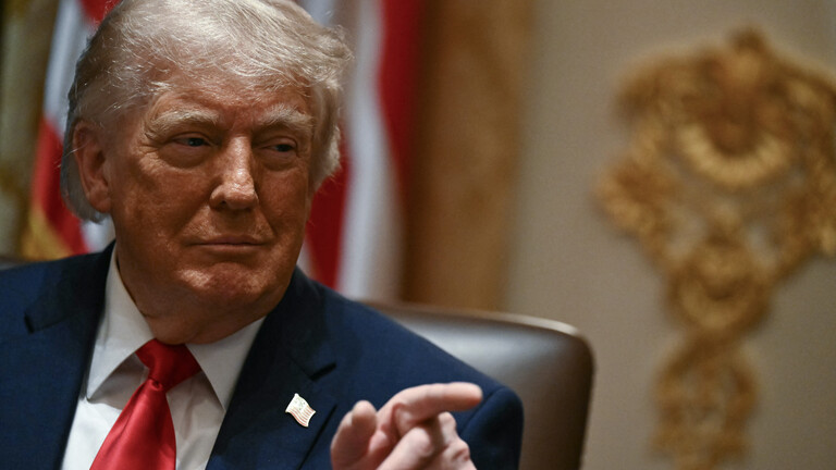 Portrait von Donald Trump vor einer US-Flagge, er zeigt mit dem Finger nach rechts