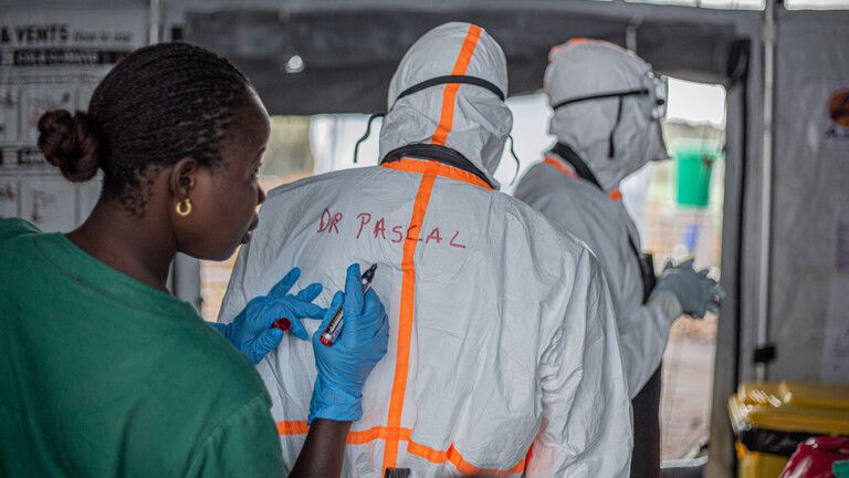 Ein Mitarbeiter des Hygieneteams schreibt den Namen eines Arztes auf die Rückseite seiner persönlichen Schutzausrüstung (PSA), bevor er das Rwampara-Ebola-Behandlungszentrum (ETC) betritt, um Patienten mit der Ebola-Virus-Krankheit in Bunia, Ituri, im Osten der Demokratischen Republik Kongo zu versorgen.