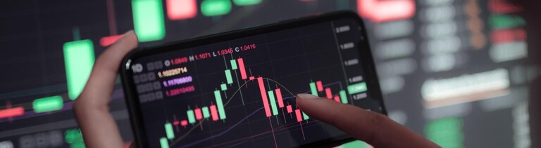 Verlauf eines Aktienkurses auf großem Bildschirm und auf einem Smartphone