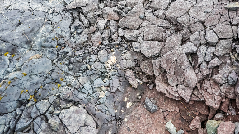 Nahaufnahme von Basaltfelsen mit verschiedenen Texturen und Rissen auf Island.