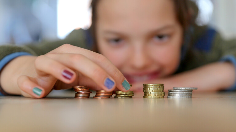 Ein Mädchen zählt am 22.04.2025 in Hamburg Geldmünzen