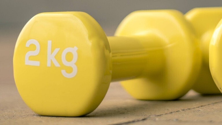 Gelbe Hanteln mit einem Gewicht von zwei Kilogramm.