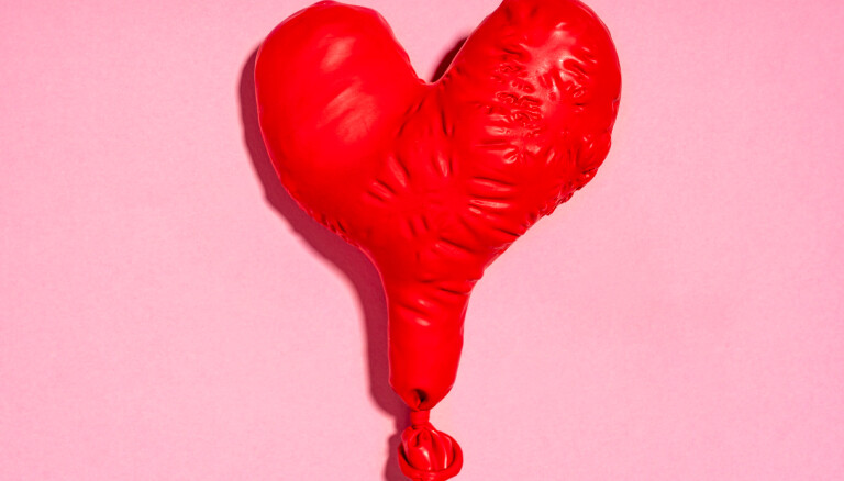 Studio shot of red heart shaped deflated balloon