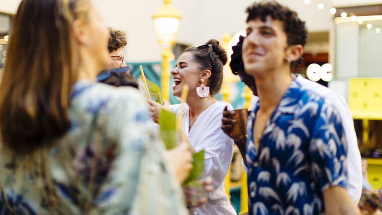 Eine Gruppe junger Menschen tanzt draußen in einem Innenhof.