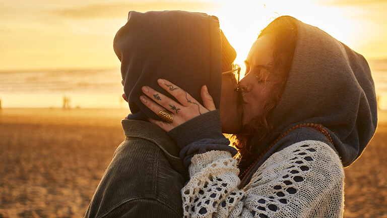 Foto eines jungen Paares, dass sich im Sonnenuntergang küsst