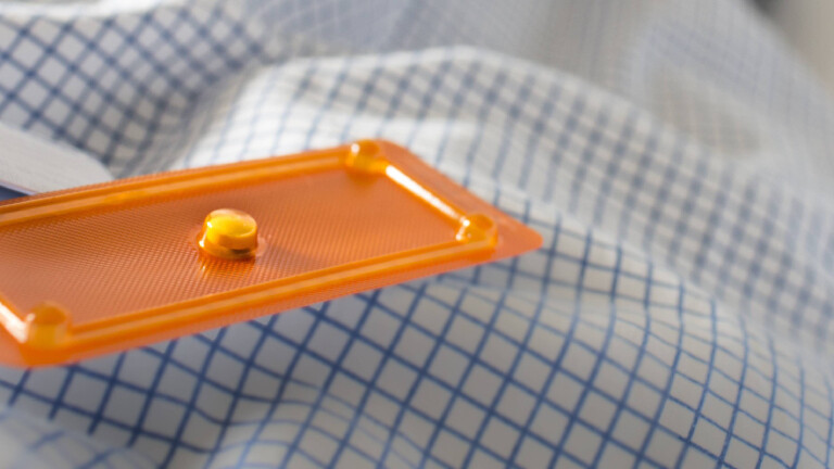 Ein Exemplar der sogenannten Pille danach liegt auf einer Bettdecke