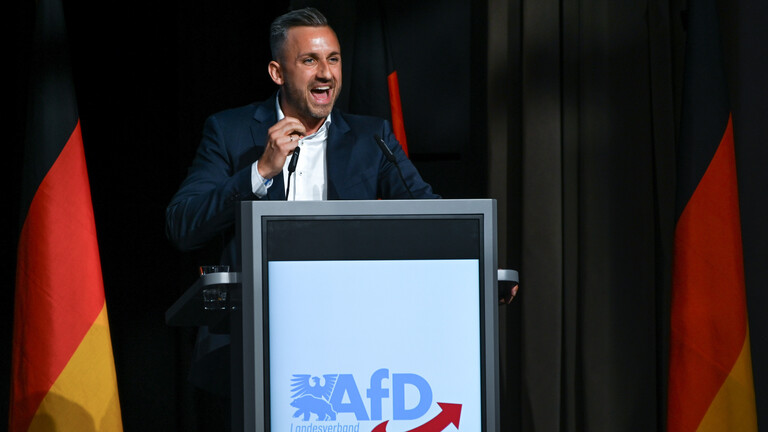Ulrich Siegmund, Spitzenkandidat der AfD in Sachsen-Anhalt, umgeben von Deutschlandflaggen bei seiner Rede vor den Teilnehmern des Landesparteitages.