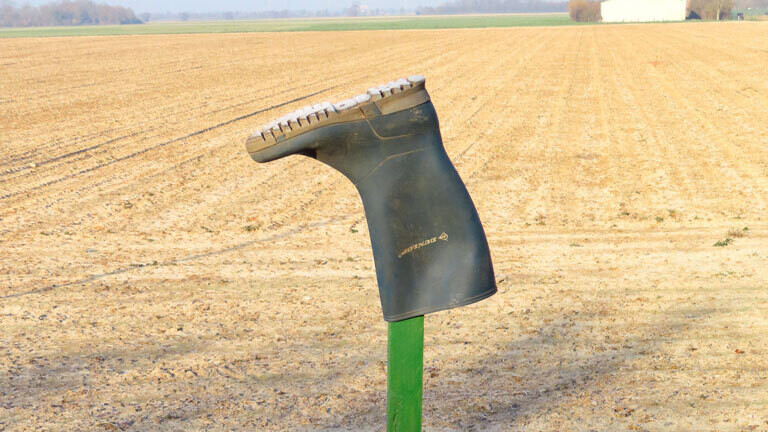 Ein Gummistiefel hängt aus Protest an einem Kreuz